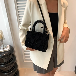 Chic black quilted handbag with fringe texture and gold hardware for women
