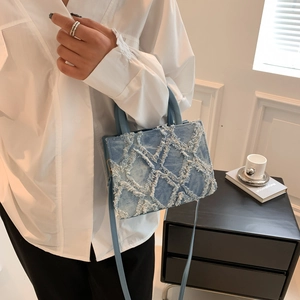 Chic light blue denim tote bag with quilted diamond pattern and fringe edge details
