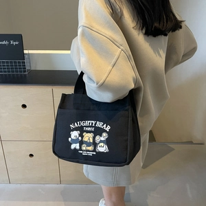 Black canvas tote bag featuring cute cartoon bear prints and outer pocket for women