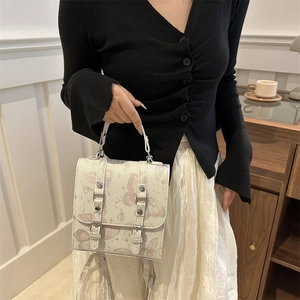 Cream-white crossbody bag with pink butterfly prints and decorative silver buckles