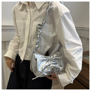 Detail of silver metallic bow shoulder bag with scrunchie strap and wrinkled texture
