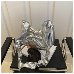 Detail of silver metallic bow handbag with pleated shoulder strap in Y2K style
