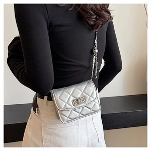Silver quilted crossbody bag detail showing metallic mirror finish and chain strap
