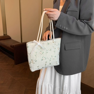Sac fourre-tout tissé minimaliste avec broderies vertes et nœud en dentelle blanche
