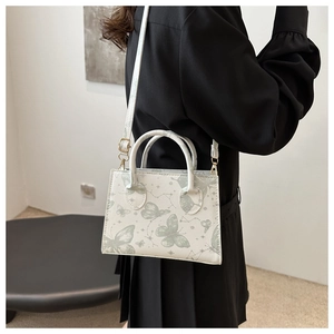 Close-up of white butterfly print crossbody bag with Saffiano leather texture and star pattern