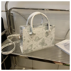 Vue détaillée du sac en cuir texturé avec imprimés papillons verts et motifs étoilés