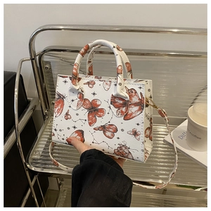 Détail du sac cabas blanc à imprimé papillon avec bandoulière réglable en décor de café