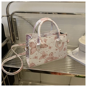 Détail du sac cabas blanc avec imprimés papillons roses et bandoulière amovible
