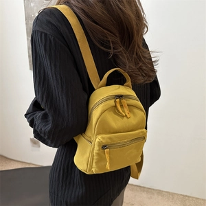 Minimalist ginger yellow small backpack with smooth texture and double zip compartments