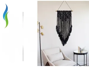 Close-up of black bohemian handmade wall hanging with feathers and woven cotton rope