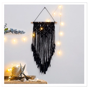 Detail of black handmade dreamcatcher wall hanging with feathers and LED lights