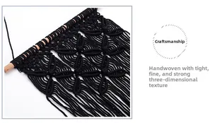 Detailed view of hand-woven black macrame wall hanging with intricate diamond patterns