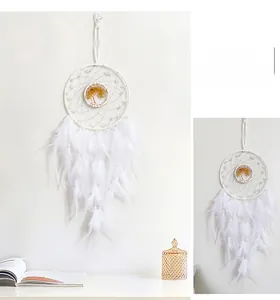 Detail of white dreamcatcher with layered feathers and woven tree pattern decoration