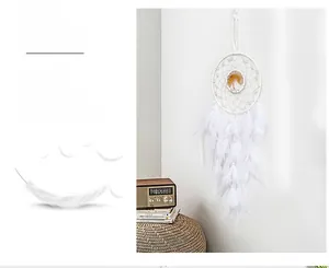 Detail view of handmade white dream catcher with feathers and yellow tree ornament