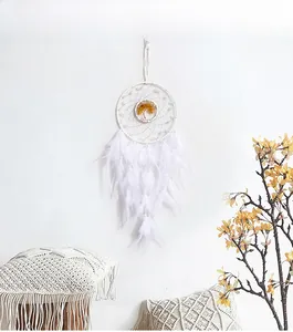 Macro detail of white dreamcatcher with tree of life emblem and soft hanging feathers