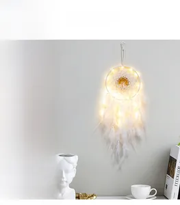 Detail of white feather dreamcatcher with warm LED lights and tree of life ornament