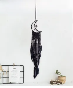 Close-up of handmade black moon dream catcher with woven knots and natural feathers