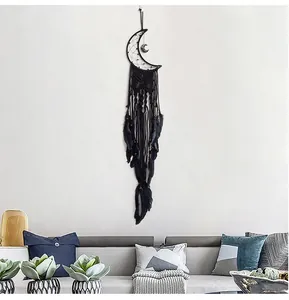Detail of handcrafted black feather dreamcatcher with moon weaving for wall decor