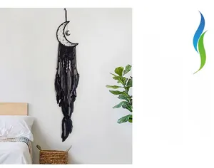 Detail of handmade black moon dream catcher with woven pattern and soft hanging feathers
