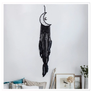 Detail of handmade black moon dream catcher featuring soft feathers and woven cotton ropes