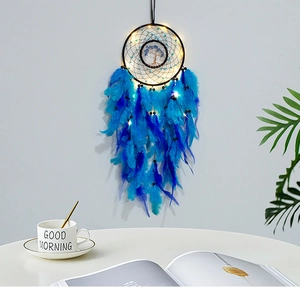 Glow dreamcatcher wall decor with blue feathers and Tree of Life in home setting