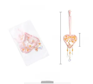 Detail of pink crystal Tree of Life heart pendant hanging with dimensions in a clear bag