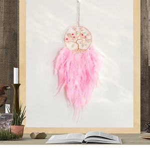 Detailed pink dreamcatcher with tree of life and feathers in a boho home decor setting