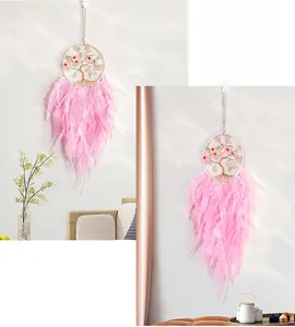 Detail of pink feather dreamcatcher with tree of life design and floral accents