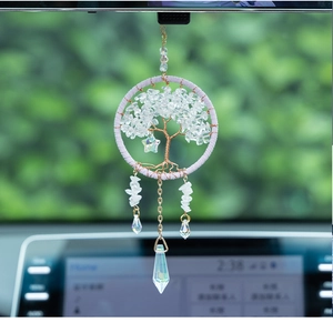 Macro shot of Tree of Life car pendant with white crystal leaves and prism pendants