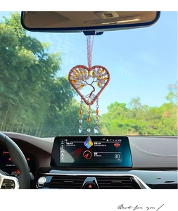 Pink heart-shaped tree of life car charm with crystals hanging on rearview mirror