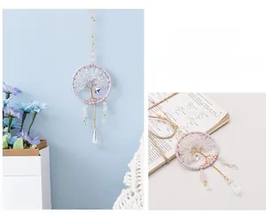 Detail of life tree dream catcher with purple threads, white crystals and colorful pendant