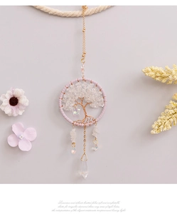 Detailed tree of life car charm with crystals and moon pendant on a warm background
