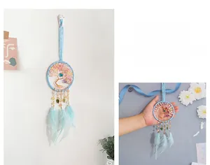 Detail of light blue dream catcher with tree of life design and soft feathers