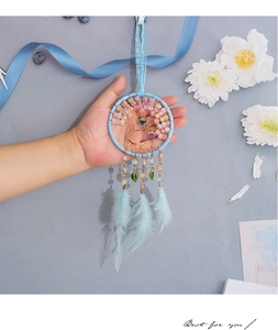 Detailed view of handmade Tree of Life dreamcatcher with blue feathers and beads