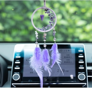 Detail of a purple dream catcher car pendant featuring amethyst stones and soft feathers