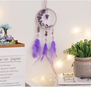 Close-up of purple car dreamcatcher charm with crystals, feathers and woven ring detail