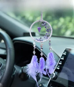 Macro detail of a purple dreamcatcher car pendant with crystal stones and soft feathers