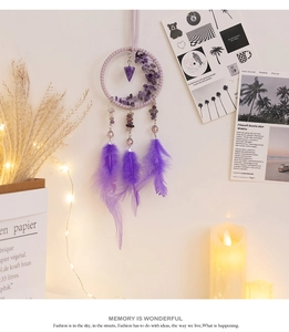 Detail of purple dreamcatcher car pendant with amethyst stones and soft feathers