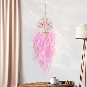 Pink Tree of Life dream catcher with feathers and beads on a clean white interior wall