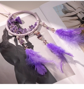 Detail view of purple dreamcatcher car pendant with amethyst stones and soft feathers