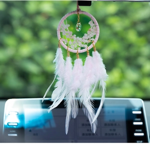 Detail of pink car dream catcher with quartz stones and soft white feather pendants
