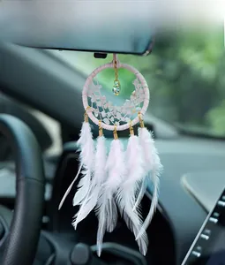 Pink dreamcatcher car mirror charm with feathers and rose quartz stones in car interior