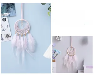 Detail of pink dream catcher hanging ornament with feathers and crystals for car interior