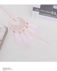 Macro shot of handmade pink dreamcatcher car pendant with feathers and crystals