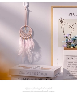 Detail of pink crystal dreamcatcher car charm with delicate feathers and woven net