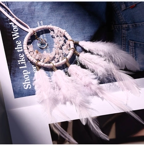 Macro detail of pink dreamcatcher car pendant with feathers and crystal stone beads