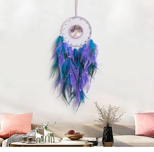 Close-up of handmade Tree of Life dreamcatcher pendant with purple amethyst and feathers