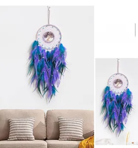 Detail of dream catcher wall hanging with purple feathers and gemstone tree of life
