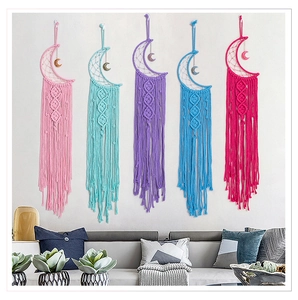 Detail of five moon-shaped macrame wall hangings in vibrant colors on a white wall