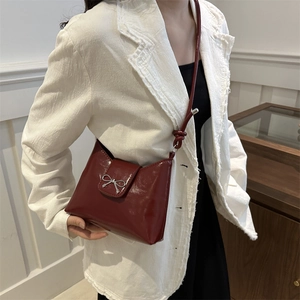 Sac à bandoulière chic en cuir bordeaux avec nœud argenté pour un look moderne élégant
